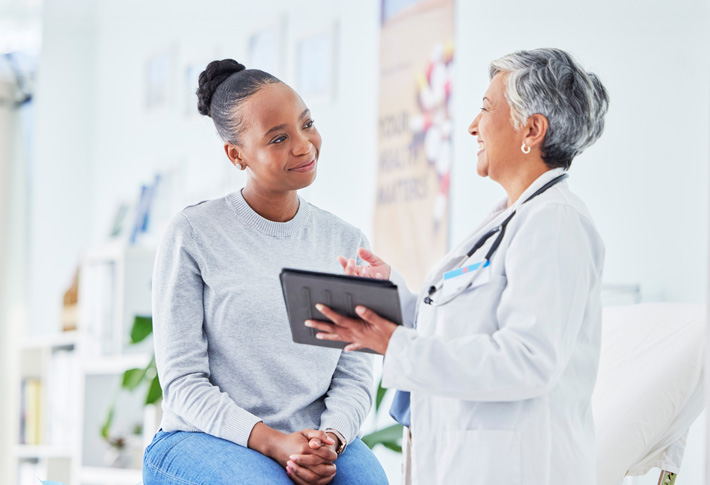 Doctor consulting with patient holding tablet